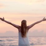 Woman Holding Arms Out While Watching the Sunset