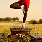 Woman Standing on Picnic Table in Yoga Pose