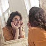 Woman Smiling in Front of Mirror
